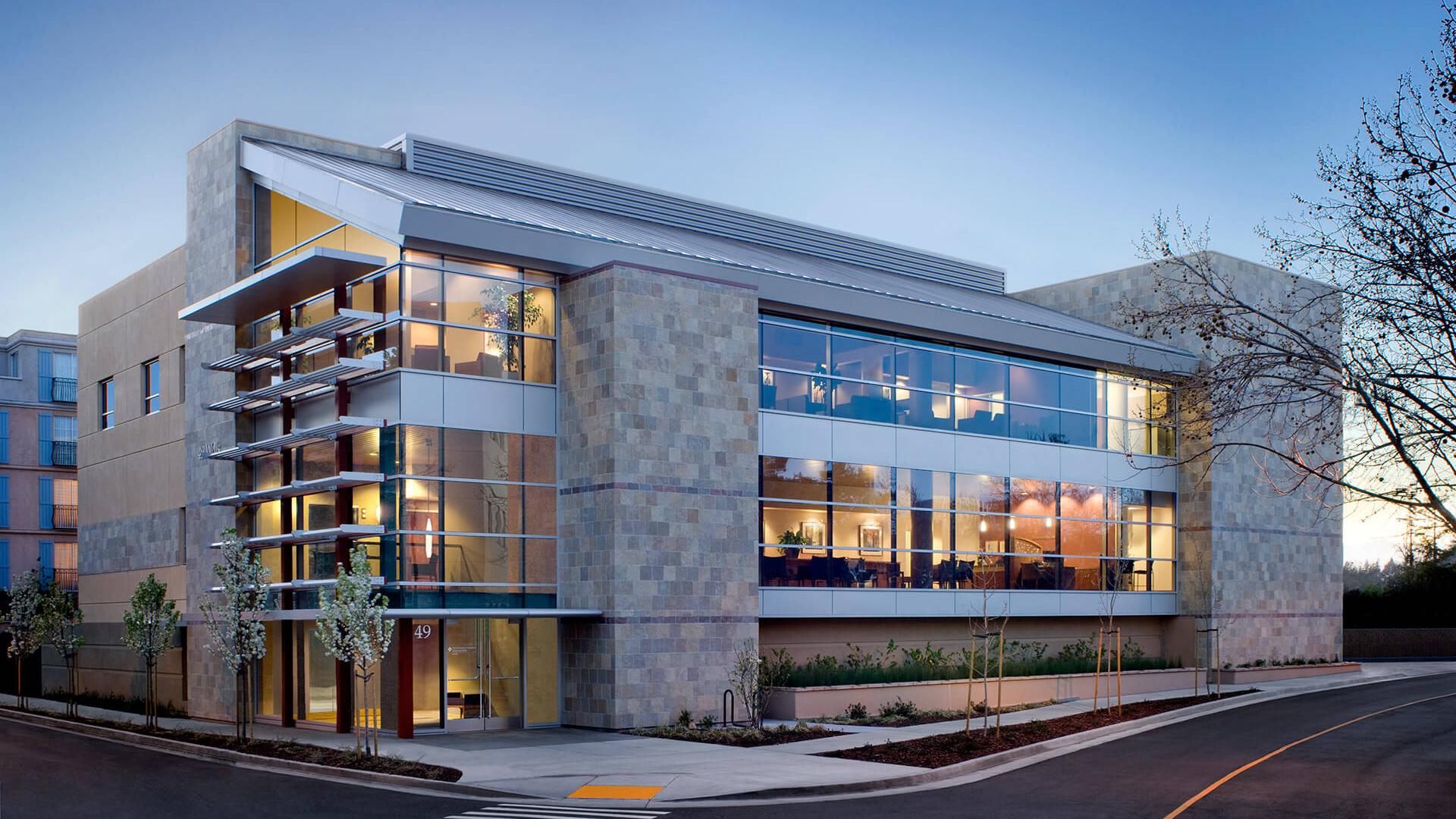 Dusk view of the medical center featuring stone walls and modern design