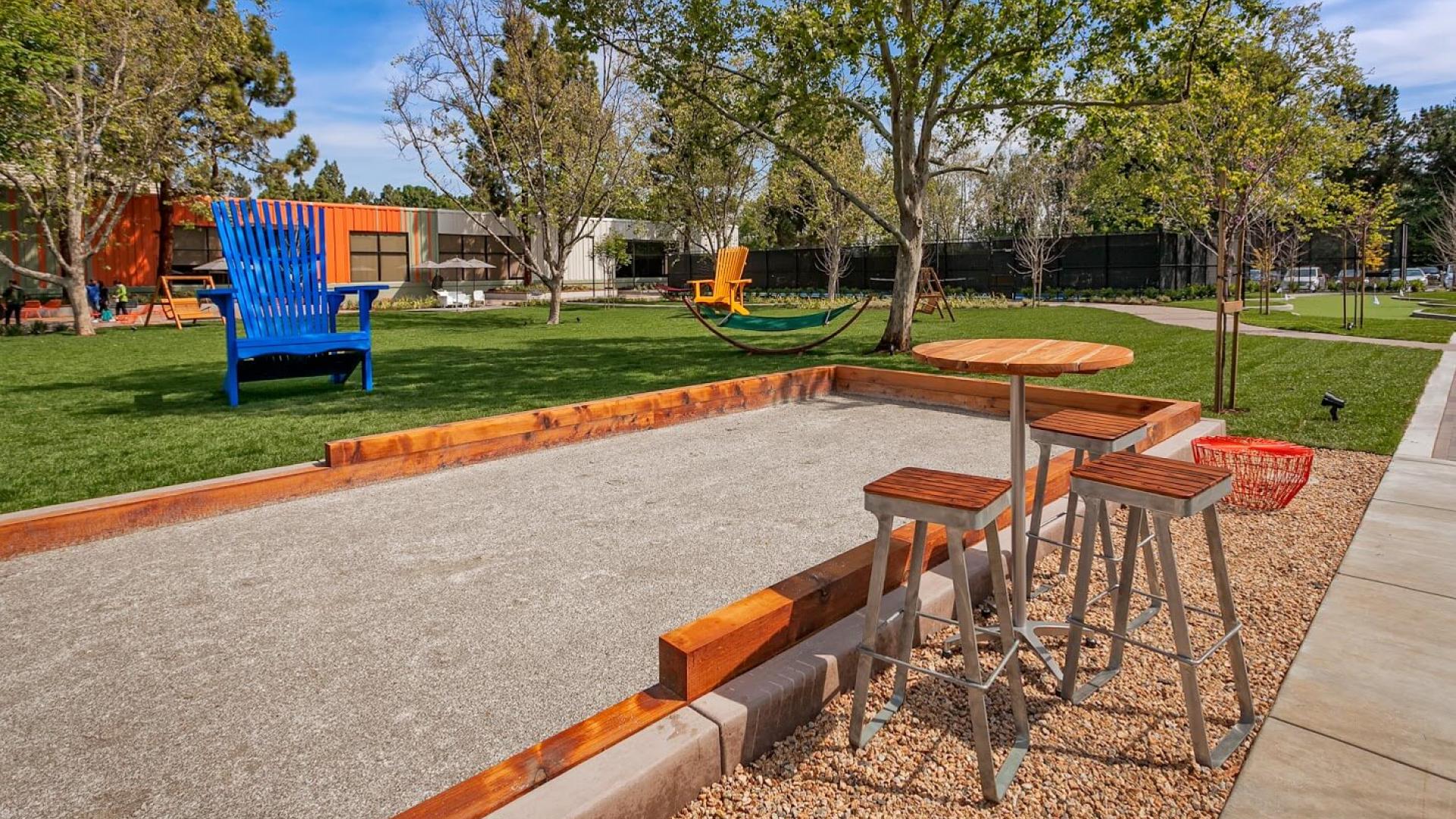 Transformation of parking lot into green space featuring amenities such as bocce ball court