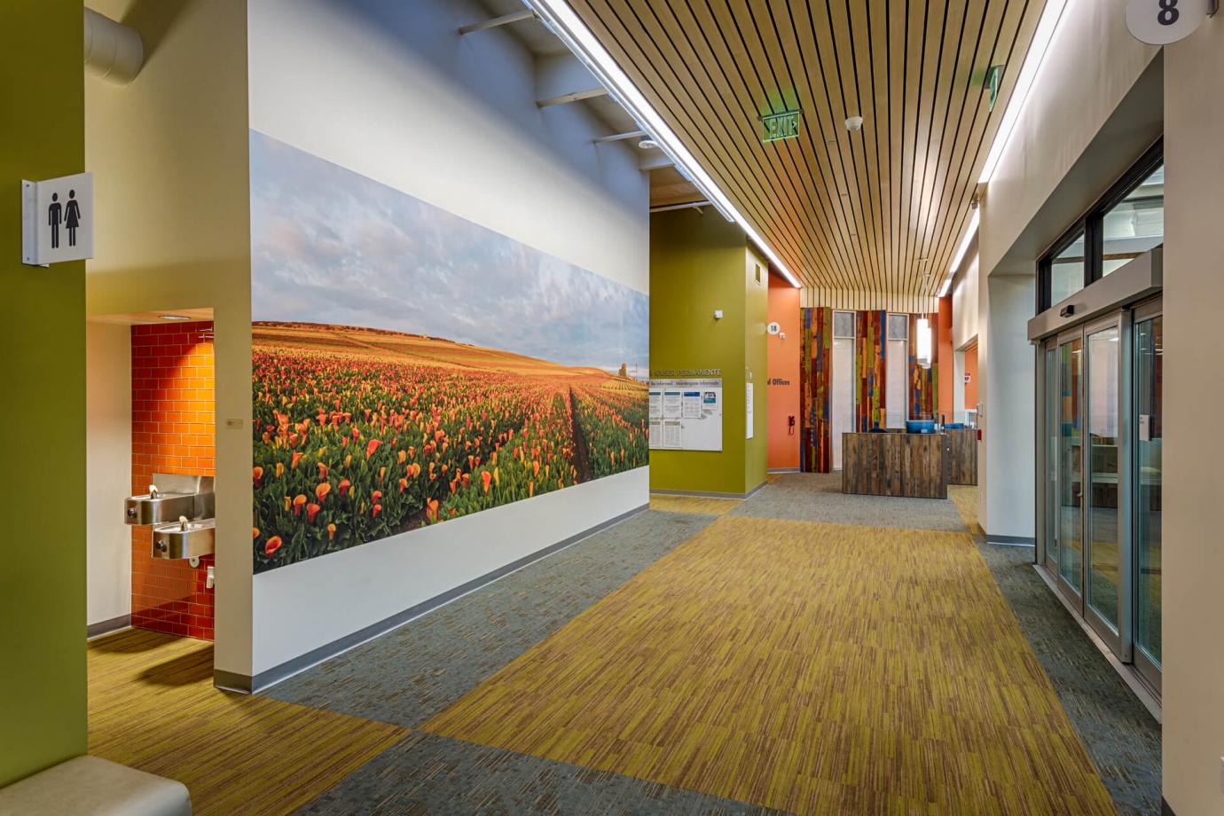 Local artist photograph of Cala Lily fields against a foggy coastal sky. Bright orange glass tile in the adjacent alcove was obtained through a local business.